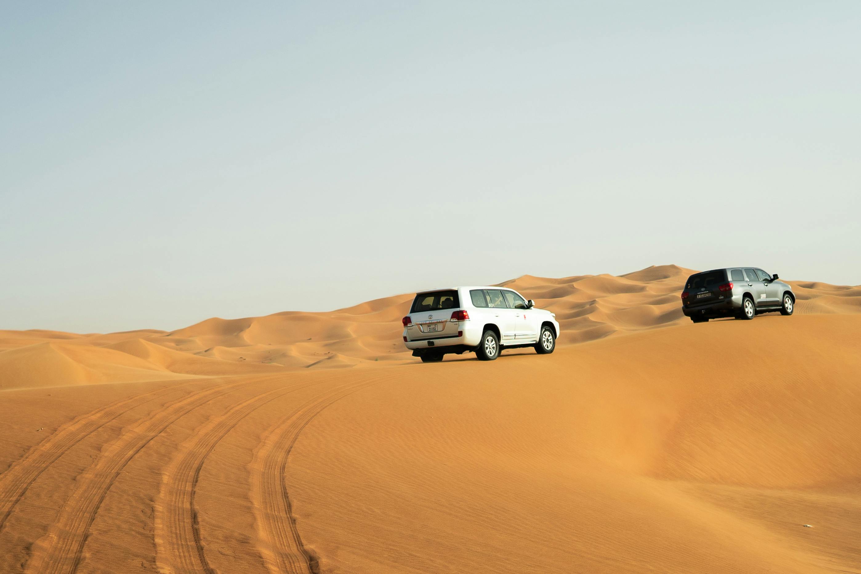 Desert safari SUVs driving across Dubai dunes